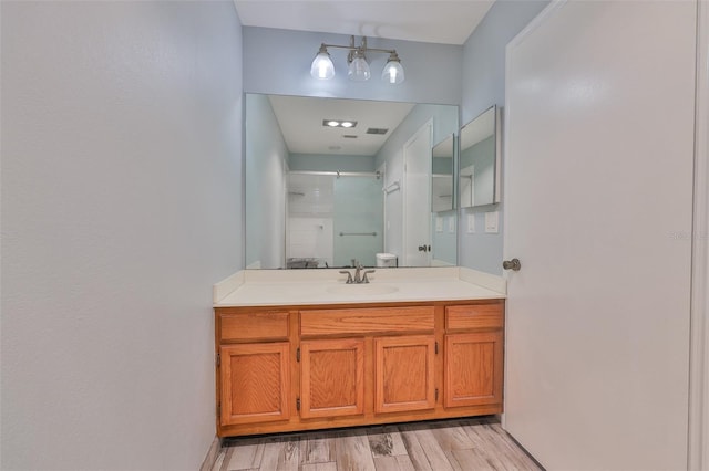1717 Atrium Dr, Sun City Center, FL 33573 - bathroom with vanity, a shower with shower door, and wood finished floors