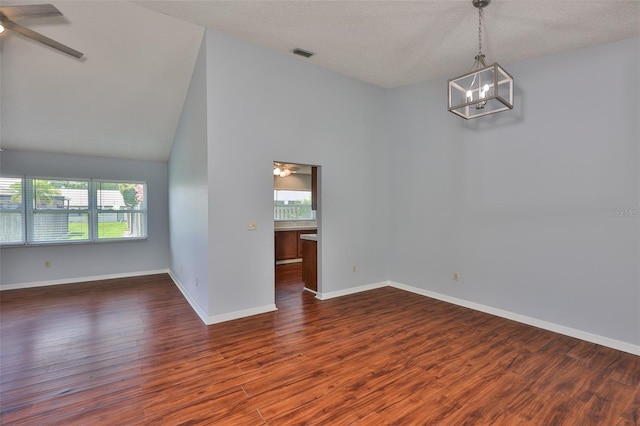 1717 Atrium Dr, Sun City Center, FL 33573 - spare room with a ceiling fan, healthy amount of natural light, a chandelier, dark wood-type flooring, and vaulted ceiling