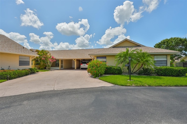 1717 Atrium Dr, Sun City Center, FL 33573 - ranch-style house featuring concrete driveway, a front lawn, and an attached carport