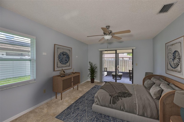 1717 Atrium Dr, Sun City Center, FL 33573 - bedroom with light colored carpet, access to exterior, a textured ceiling, and ceiling fan