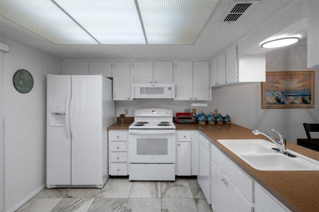 7433 Greystone Dr Unit 7433, Hudson, FL 34667 - kitchen with white appliances, white cabinets, light marble finish floors, and dark countertops