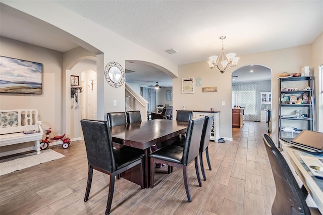 2073 Branding Iron Way, New Port Richey, FL 34655 - dining area with arched walkways, light wood-style flooring, a chandelier, ceiling fan, and stairs