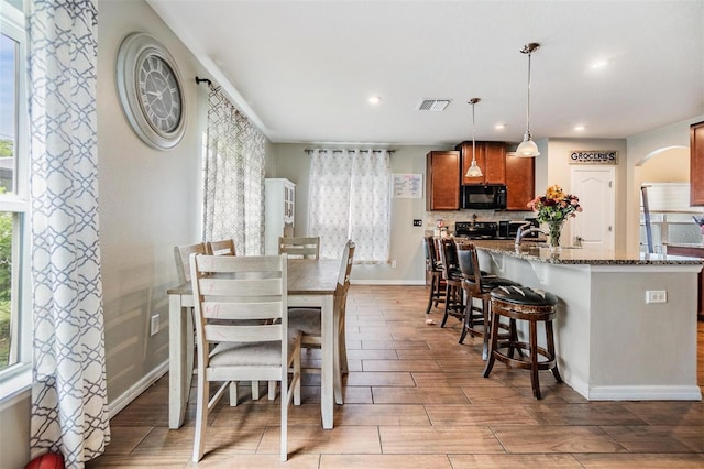 2073 Branding Iron Way, New Port Richey, FL 34655 - dining area featuring arched walkways, light wood finished floors, and recessed lighting