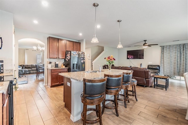 2073 Branding Iron Way, New Port Richey, FL 34655 - kitchen featuring stainless steel appliances, open floor plan, a ceiling fan, light wood-type flooring, and brown cabinets