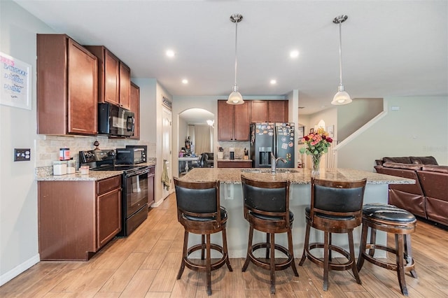 2073 Branding Iron Way, New Port Richey, FL 34655 - kitchen featuring black appliances, arched walkways, backsplash, a kitchen bar, and recessed lighting