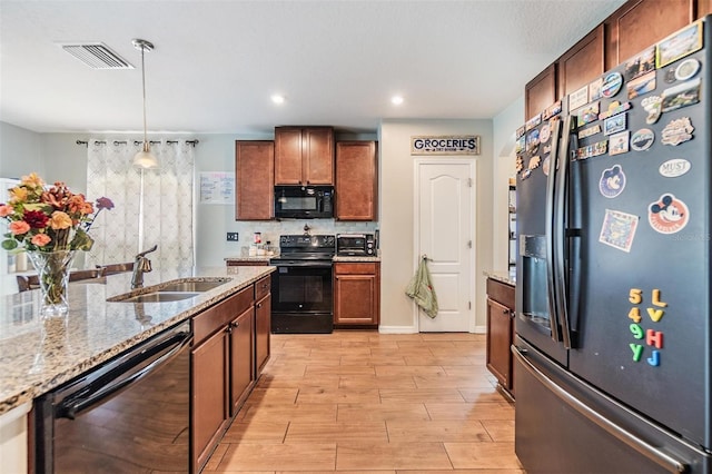 2073 Branding Iron Way, New Port Richey, FL 34655 - kitchen with black appliances, decorative light fixtures, light wood finished floors, light stone countertops, and tasteful backsplash