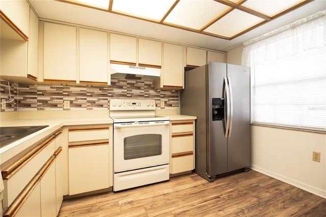 2400 Winding Creek Blvd Unit Bldg18A # 210, Clearwater, FL 33761 - kitchen featuring white range with electric stovetop, under cabinet range hood, stainless steel fridge with ice dispenser, backsplash, and light countertops