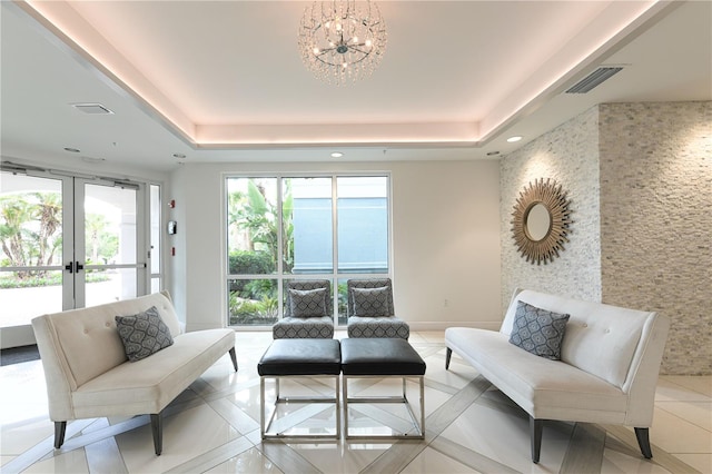 10520 Boardwalk Loop Unit 202, Bradenton, FL 34202 - living room featuring a chandelier, a tray ceiling, french doors, recessed lighting, and light tile patterned flooring