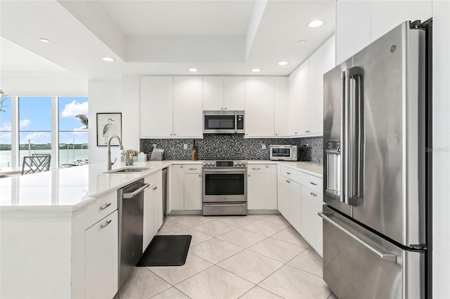 706 Bayway Blvd Unit 503, Clearwater, FL 33767 - kitchen with appliances with stainless steel finishes, a peninsula, tasteful backsplash, light countertops, and recessed lighting
