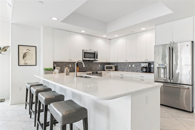 706 Bayway Blvd Unit 503, Clearwater, FL 33767 - kitchen featuring stainless steel appliances, light tile patterned flooring, a breakfast bar area, recessed lighting, and a peninsula