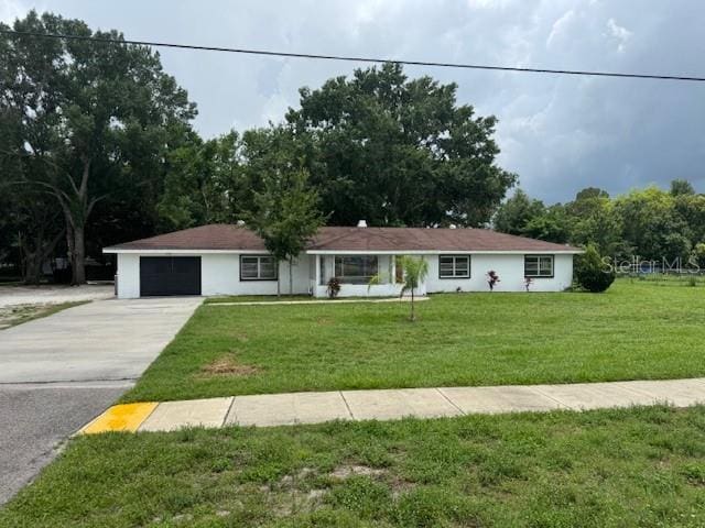 17048 State Road 54, Lutz, FL 33558 - ranch-style home featuring concrete driveway, a front lawn, and an attached garage