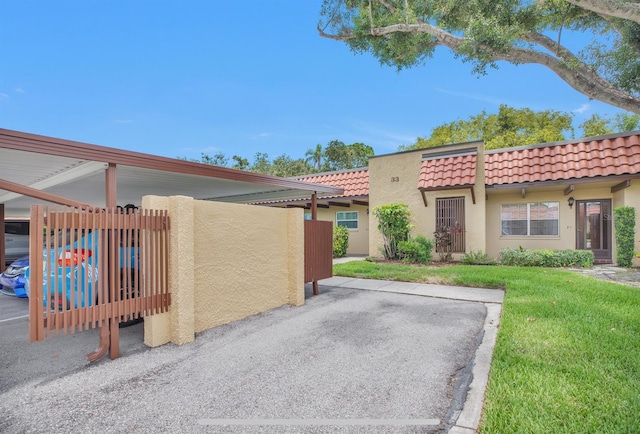 1701 Pinehurst Rd Unit 33E, Dunedin, FL 34698 - view of home's exterior with a tile roof, stucco siding, and a yard