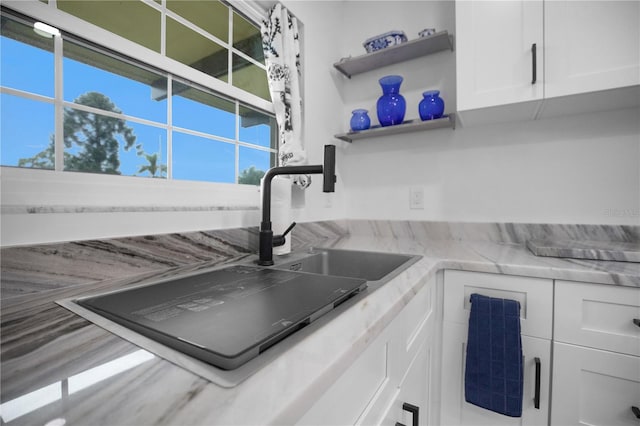 1701 Pinehurst Rd Unit 33E, Dunedin, FL 34698 - kitchen with white cabinets, open shelves, and light stone counters