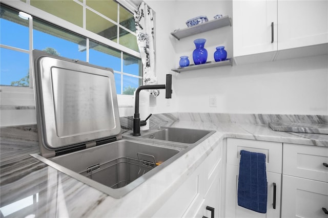 1701 Pinehurst Rd Unit 33E, Dunedin, FL 34698 - kitchen with white cabinets, open shelves, and light stone counters