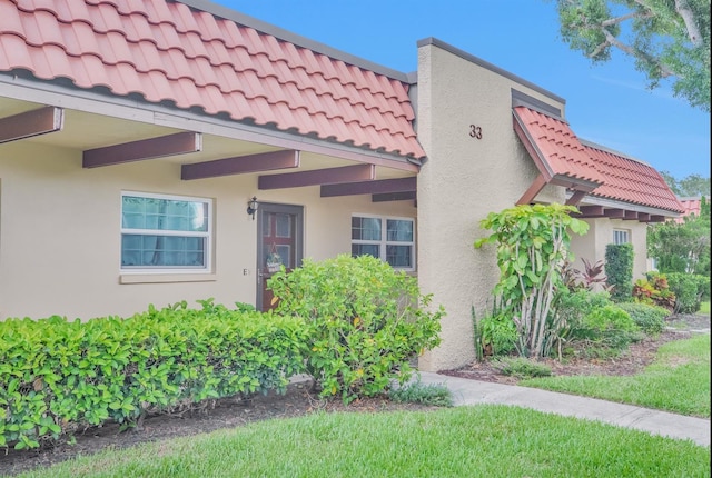 1701 Pinehurst Rd Unit 33E, Dunedin, FL 34698 - view of side of property with stucco siding and a tiled roof