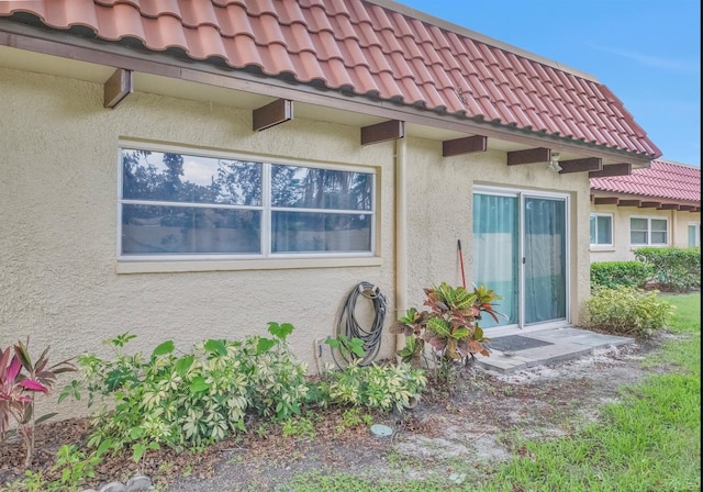 1701 Pinehurst Rd Unit 33E, Dunedin, FL 34698 - view of exterior entry featuring a tiled roof and stucco siding