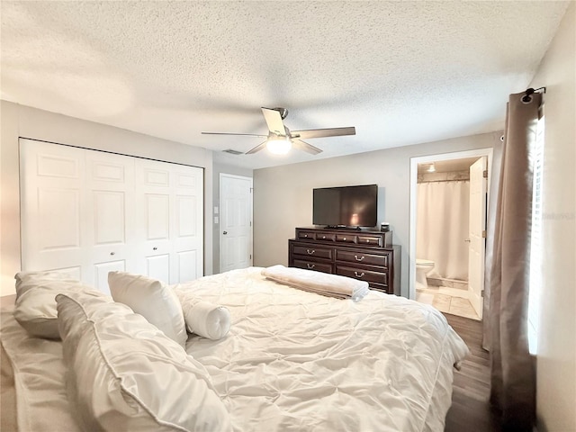 630 Timber Bay Cir W, Oldsmar, FL 34677 - bedroom with a closet, a textured ceiling, a ceiling fan, wood finished floors, and ensuite bath