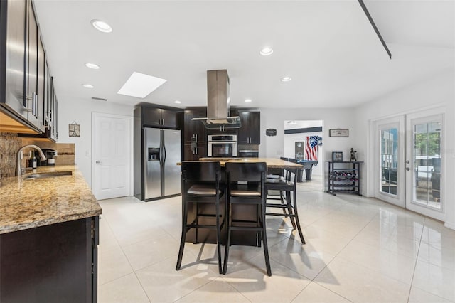 3509 Country Creek Ln, Valrico, FL 33596 - kitchen featuring stainless steel appliances, island range hood, a skylight, decorative backsplash, and a breakfast bar