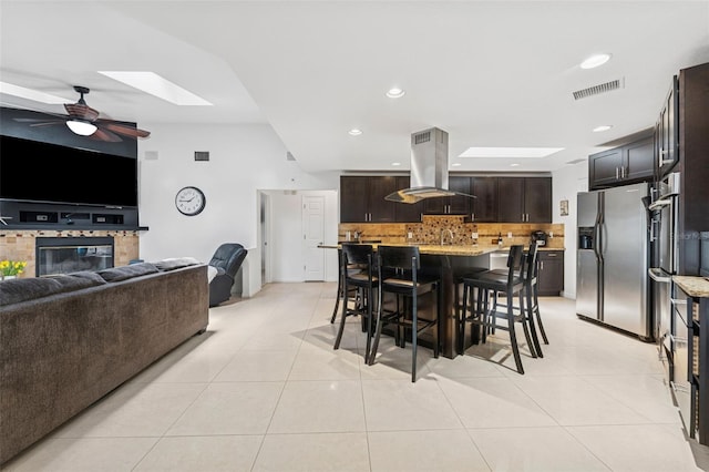 3509 Country Creek Ln, Valrico, FL 33596 - dining space featuring ceiling fan, light tile patterned floors, a glass covered fireplace, a skylight, and recessed lighting