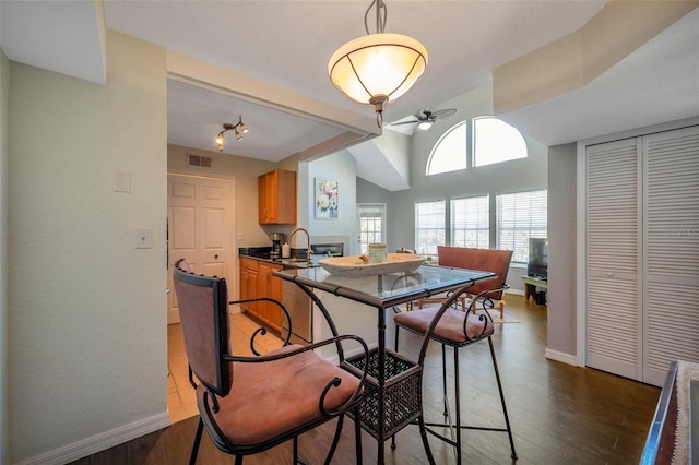 3301 Haviland Ct Unit 301, Palm Harbor, FL 34684 - dining space featuring a ceiling fan, wood finished floors, and vaulted ceiling