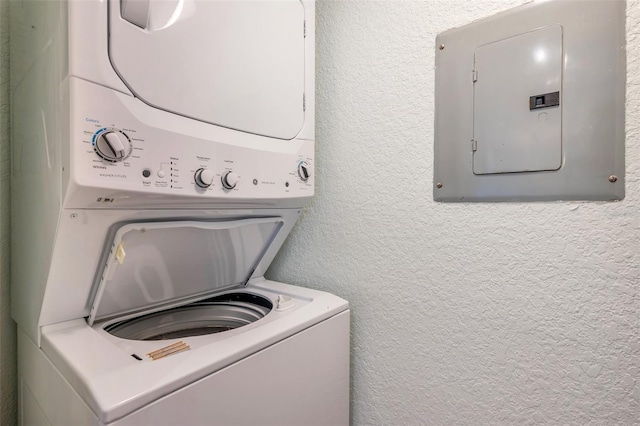 3301 Haviland Ct Unit 301, Palm Harbor, FL 34684 - laundry room featuring stacked washer / dryer, electric panel, and a textured wall