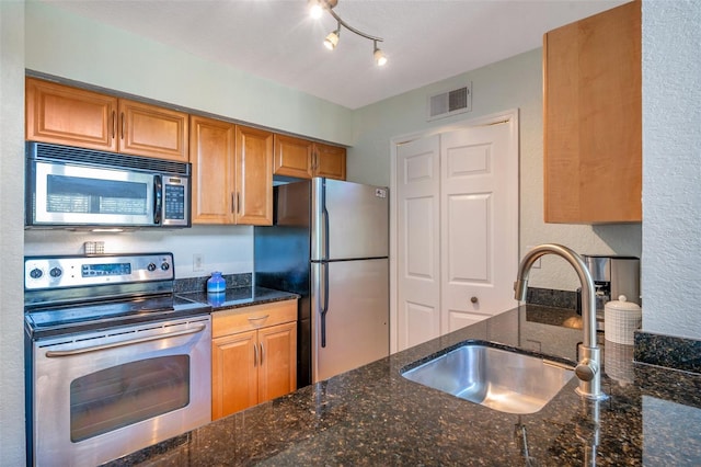 3301 Haviland Ct Unit 301, Palm Harbor, FL 34684 - kitchen with stainless steel appliances, dark stone countertops, and brown cabinets