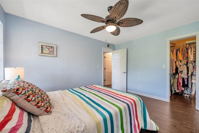 3301 Haviland Ct Unit 301, Palm Harbor, FL 34684 - bedroom with wood finished floors, a spacious closet, a textured ceiling, a ceiling fan, and a closet