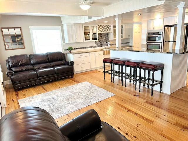 20111 County Line Rd, Lutz, FL 33558 - living room with decorative columns, light wood-style floors, and a ceiling fan