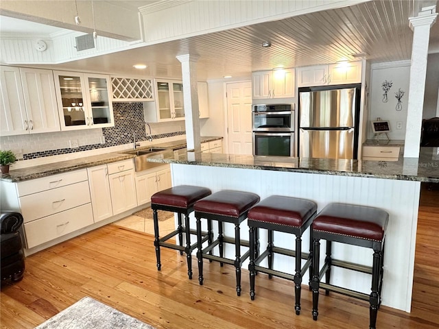 20111 County Line Rd, Lutz, FL 33558 - kitchen with appliances with stainless steel finishes, ornate columns, a kitchen breakfast bar, tasteful backsplash, and ornamental molding