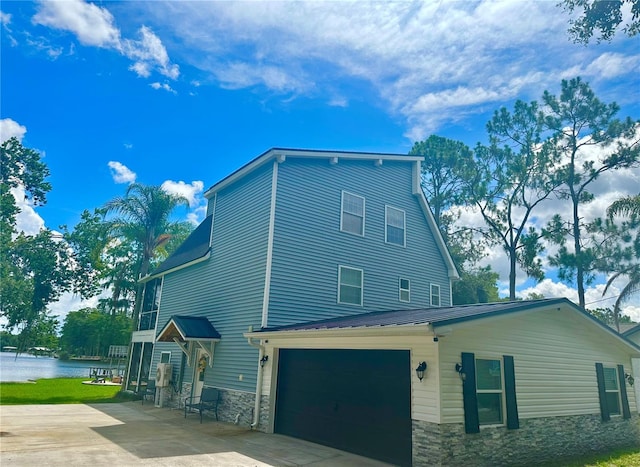 20111 County Line Rd, Lutz, FL 33558 - view of home's exterior featuring stone siding, driveway, and a water view