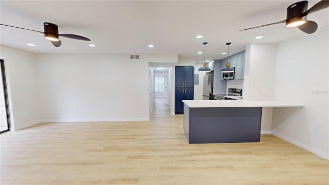 3232 Lake Pine Way E Unit A2, Tarpon Springs, FL 34688 - kitchen featuring ceiling fan, appliances with stainless steel finishes, blue cabinets, a peninsula, and light countertops
