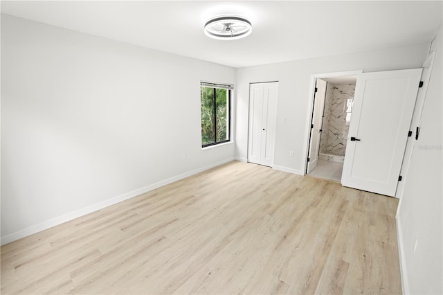 3232 Lake Pine Way E Unit A2, Tarpon Springs, FL 34688 - unfurnished bedroom featuring light wood-style flooring, connected bathroom, and a closet