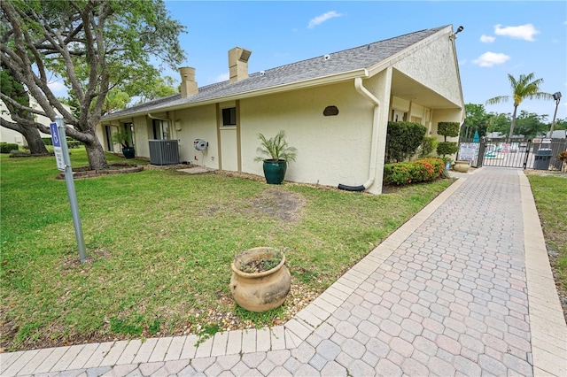3232 Lake Pine Way E Unit A2, Tarpon Springs, FL 34688 - view of side of property featuring a gate, stucco siding, and a chimney