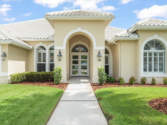 6905 Arabian Rd, Odessa, FL 33556 - view of exterior entry featuring a tiled roof, a yard, and stucco siding