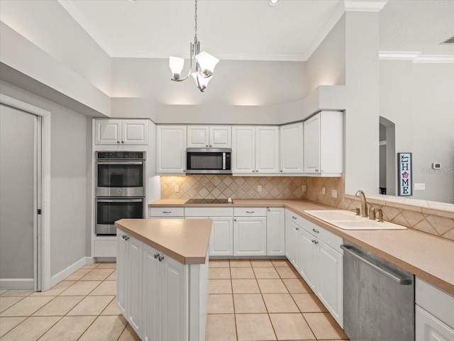 6905 Arabian Rd, Odessa, FL 33556 - kitchen featuring appliances with stainless steel finishes, light tile patterned floors, a chandelier, light countertops, and crown molding