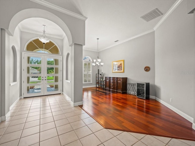 6905 Arabian Rd, Odessa, FL 33556 - tiled entrance foyer featuring a chandelier, french doors, arched walkways, wine cooler, and ornamental molding