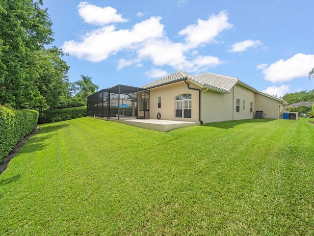6905 Arabian Rd, Odessa, FL 33556 - rear view of house with a patio area, a yard, glass enclosure, and stucco siding
