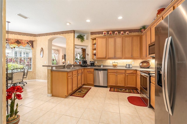 6041 Sandhill Ridge Dr, Lithia, FL 33547 - kitchen with stainless steel appliances, a peninsula, light tile patterned floors, arched walkways, and open shelves