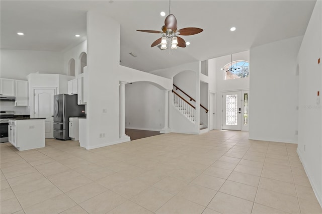 19206 Ivy Oak Way, Tampa, FL 33647 - unfurnished living room featuring high vaulted ceiling, ceiling fan, stairway, light tile patterned floors, and arched walkways