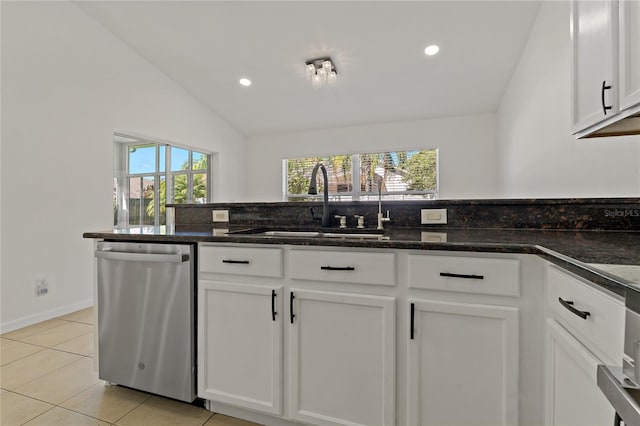 19206 Ivy Oak Way, Tampa, FL 33647 - kitchen with stainless steel dishwasher, plenty of natural light, white cabinetry, lofted ceiling, and light tile patterned floors
