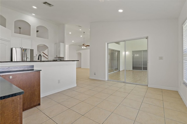 19206 Ivy Oak Way, Tampa, FL 33647 - kitchen featuring freestanding refrigerator, a ceiling fan, dark countertops, white cabinets, and light tile patterned flooring