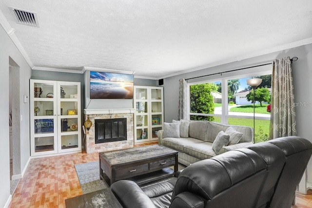 901 Strawberry Ln, Brandon, FL 33511 - living room with crown molding, a stone fireplace, a textured ceiling, and wood finished floors