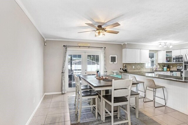 901 Strawberry Ln, Brandon, FL 33511 - dining room with light tile patterned flooring, crown molding, french doors, plenty of natural light, and a ceiling fan