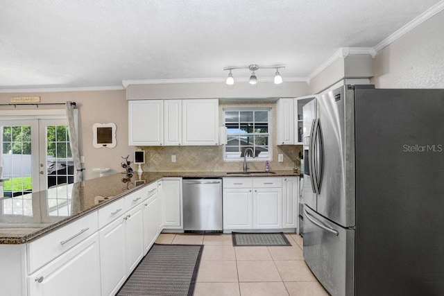 901 Strawberry Ln, Brandon, FL 33511 - kitchen with appliances with stainless steel finishes, a peninsula, decorative backsplash, white cabinets, and light tile patterned flooring