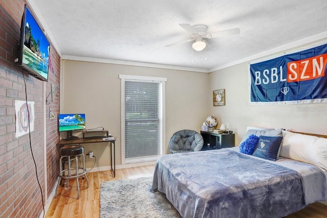 901 Strawberry Ln, Brandon, FL 33511 - bedroom featuring brick wall, wood finished floors, a textured ceiling, ornamental molding, and ceiling fan