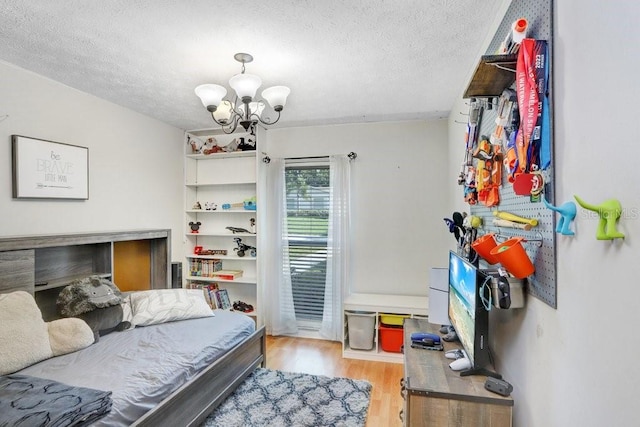 901 Strawberry Ln, Brandon, FL 33511 - bedroom featuring a chandelier, light wood-type flooring, and a textured ceiling