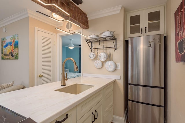 1301 S Howard Ave Unit A9, Tampa, FL 33606 - kitchen with freestanding refrigerator, glass insert cabinets, light stone countertops, ornamental molding, and white cabinetry
