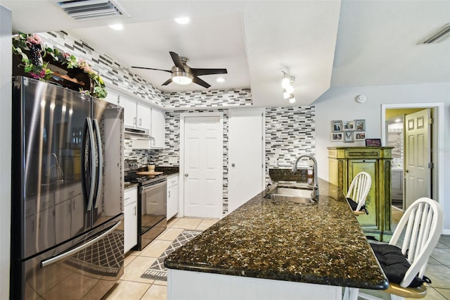 8823 Aruba Ln, Port Richey, FL 34668 - kitchen featuring freestanding refrigerator, black range with electric stovetop, under cabinet range hood, ceiling fan, and light tile patterned flooring