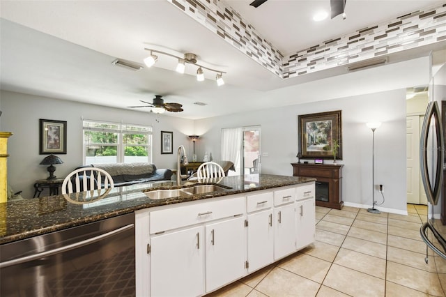 8823 Aruba Ln, Port Richey, FL 34668 - kitchen with appliances with stainless steel finishes, ceiling fan, light tile patterned flooring, dark stone countertops, and white cabinetry