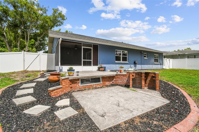 8823 Aruba Ln, Port Richey, FL 34668 - back of house with a sunroom, a patio, a fenced backyard, a gate, and a shingled roof